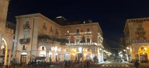 a large building with people standing outside of it at night at Agathae Home in Catania