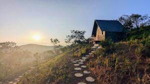 una casa al lado de una colina con un camino en Spirit of the Wild Retreat @ IMark Valley, en Attappādi