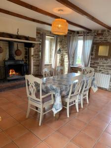 uma sala de jantar com uma mesa e cadeiras e uma lareira em Gîte la belle etoile em Ver