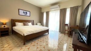een hotelkamer met een bed en een televisie bij Ay’s House in Chiang Mai