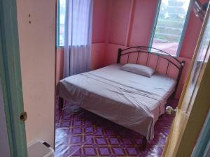 ein kleines Bett in einem Zimmer mit Fenster in der Unterkunft Kallang Tenom Homestay in Tenom