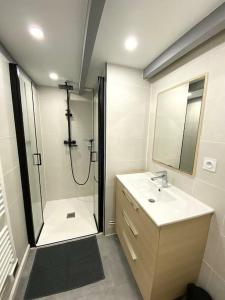 a bathroom with a shower and a sink and a mirror at L'Embellie au coeur du village de La Cotinière in La Cotinière