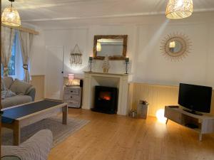 a living room with a couch and a fireplace at Gîte la belle etoile proche de Granville in Ver