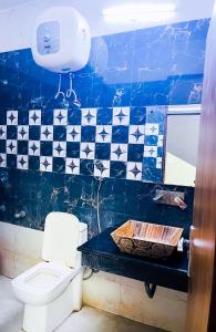 a bathroom with a toilet and a blue and white tiles at Hotel In South Delhi - Nizamuddin Dargah in New Delhi