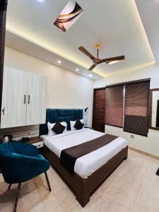 1 dormitorio con 1 cama grande y ventilador de techo en Monga Dream Residency - 5 MINUTES WALK FROM GOLDEN TEMPLE en Amritsar