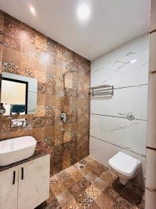 y baño con aseo, lavabo y espejo. en Monga Dream Residency - 5 MINUTES WALK FROM GOLDEN TEMPLE en Amritsar
