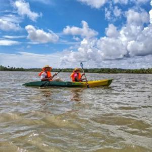dos personas en un kayak en un cuerpo de agua en Beach Island Villas en Kollam