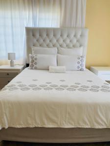 a bedroom with a large white bed with white sheets and pillows at Third Haven in Swakopmund