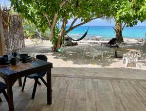 a table and chairs with a view of the beach at Rangiroa Beach House in Avatoru