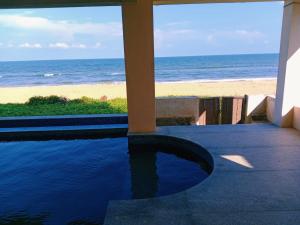 - une vue sur la plage depuis la terrasse couverte d'une maison dans l'établissement Suman beach House, à Chennai