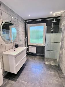 W łazience znajduje się umywalka, lustro i prysznic. w obiekcie Villa Kosta w mieście Kosta