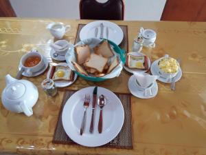 a table with plates of food and utensils on it at Oviya Guest in Nuwara Eliya