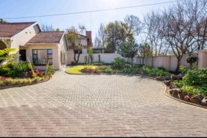 a brick driveway in front of a house at Lovely Linden Cottage with Solar Inverter in Johannesburg