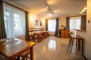 a living room with tables and chairs and windows at Zaya Hostel in Ulaanbaatar