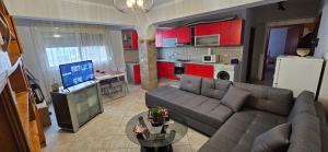 a living room with a couch and a kitchen with red cabinets at Library Apartment by Bohem Rentals in Durrës