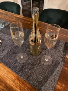três copos de vinho e uma garrafa numa mesa em Schönes Apartment mit Aussicht über Graz em Graz