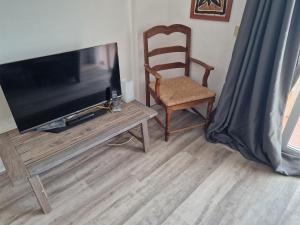 a living room with a chair and a flat screen tv at Bajamar Oasis in Bajamar
