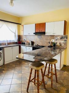a kitchen with a counter and two bar stools at Third Haven in Swakopmund