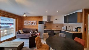 a kitchen and living room with a table and a couch at L'Étoile du Linga in Châtel