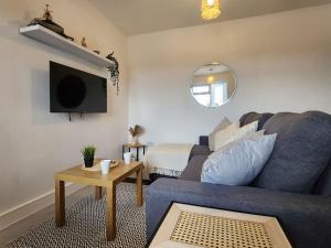 a living room with a blue couch and a bed at SuperValue Suite 3 - Fast WiFi, Hotel Linen, Keyless Entry, City only 10 Mins - BY PROPERTY PROMISE in Cardiff