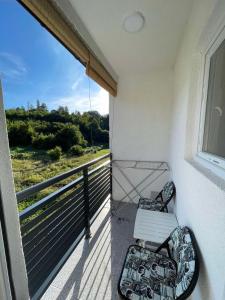 einen Balkon mit einer weißen Bank und einem Fenster in der Unterkunft Apartment Eneya in Pazarić