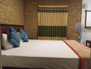 een bed met blauwe kussens in een kamer bij Ella Relax Inn in Ella