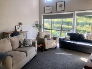 ein Wohnzimmer mit Sofa und Sessel in der Unterkunft Danara Cottage in Bathurst