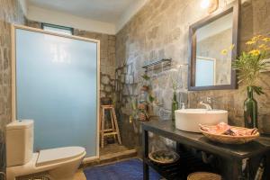 a bathroom with a toilet and a sink and a mirror at Kinigi Cottage in Kinigi