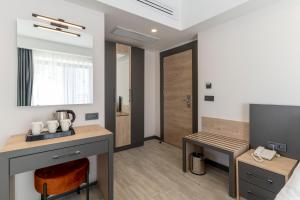 Habitación con cama, mesa y espejo. en IRENIC HOTEL, en Antalya