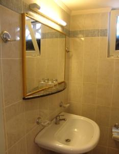 a bathroom with a sink and a mirror at Theonia Hotel in Kos Town