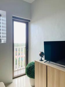 a living room with a flat screen tv and a window at * * WV 1 Minimalist Studio in Iloilo City