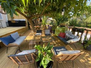 a patio with chairs and tables and a tree at Saint tropez-Gassin Bungalow LUXE 6 personnes in Gassin