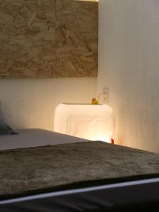 um quarto com uma cama com uma luz na parede em Vit-bau Room - Double Room 2 person - Duck Homestay Ben Tre em Ấp Phú Lợi