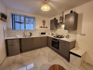 a large kitchen with a sink and a stove at ApartHotel Flat 5 - 10 min to centre by Property Promise in Cardiff