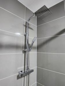 a shower with a shower head in a bathroom at ApartHotel Flat 5 - 10 min to centre by Property Promise in Cardiff