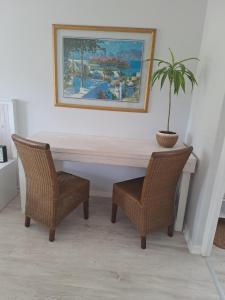 a table and two chairs with a potted plant at Plettenberg Bay 7 BUNKER AVENUE in Plettenberg Bay