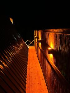 un puente de madera con luces encendidas por la noche en Sapanca Sis Vadi Bungalov en Sakarya