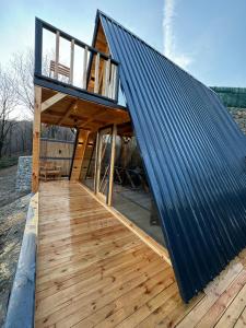 a house with a metal roof on a wooden deck at Sapanca Sis Vadi Bungalov in Sakarya