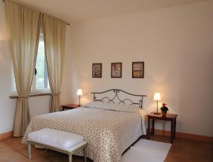 Fratta TodinaにあるAgriturismo Tenuta Conti Fainaのベッドルーム1室(ベッド1台、テーブル2台、ランプ2つ付)