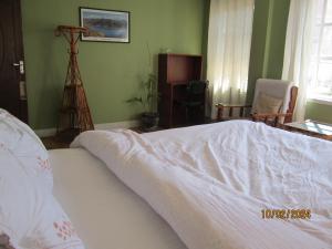 a bedroom with a bed with a white comforter at KAJI HOME in Pātan