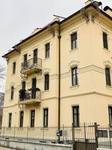 a large yellow building with windows and a fence at Casa Daniela in Trento