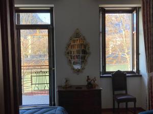 a living room with two windows and a mirror at Casa Daniela in Trento