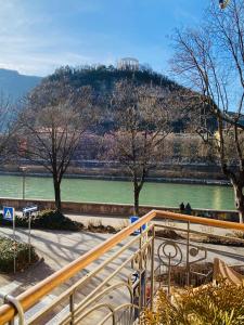 uma vista para um rio com uma colina ao fundo em Casa Daniela em Trento