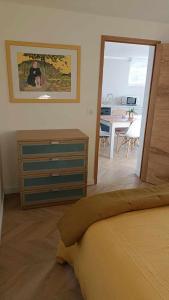 um quarto com uma cama, uma cómoda e uma sala de jantar em Bas de Villa neuf en Provence avec Piscine em Mallemoisson