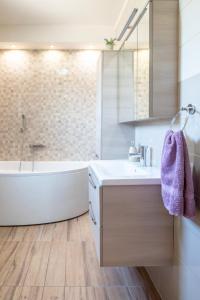 a bathroom with a white tub and a sink and a bath tub at Apartman Karlo Antonio in Trogir