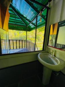 een badkamer met een wastafel en een raam met een balkon bij The Magical Tree House in Yatiyantota