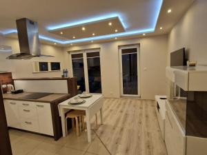 a kitchen with a small white table and a counter at Apartament morski Aquasfera in Reda