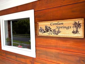 a sign on the side of a building with a window at Conlan Springs Cottage in Queenstown