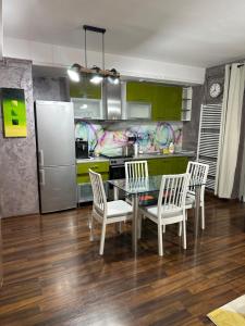 a kitchen with a table and chairs and a refrigerator at Paulina Apartament in Timişoara