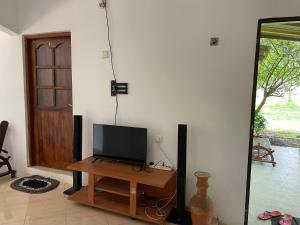 sala de estar con TV sobre una mesa de madera en Bhawana Canal View Resort, en Nochchiyagama